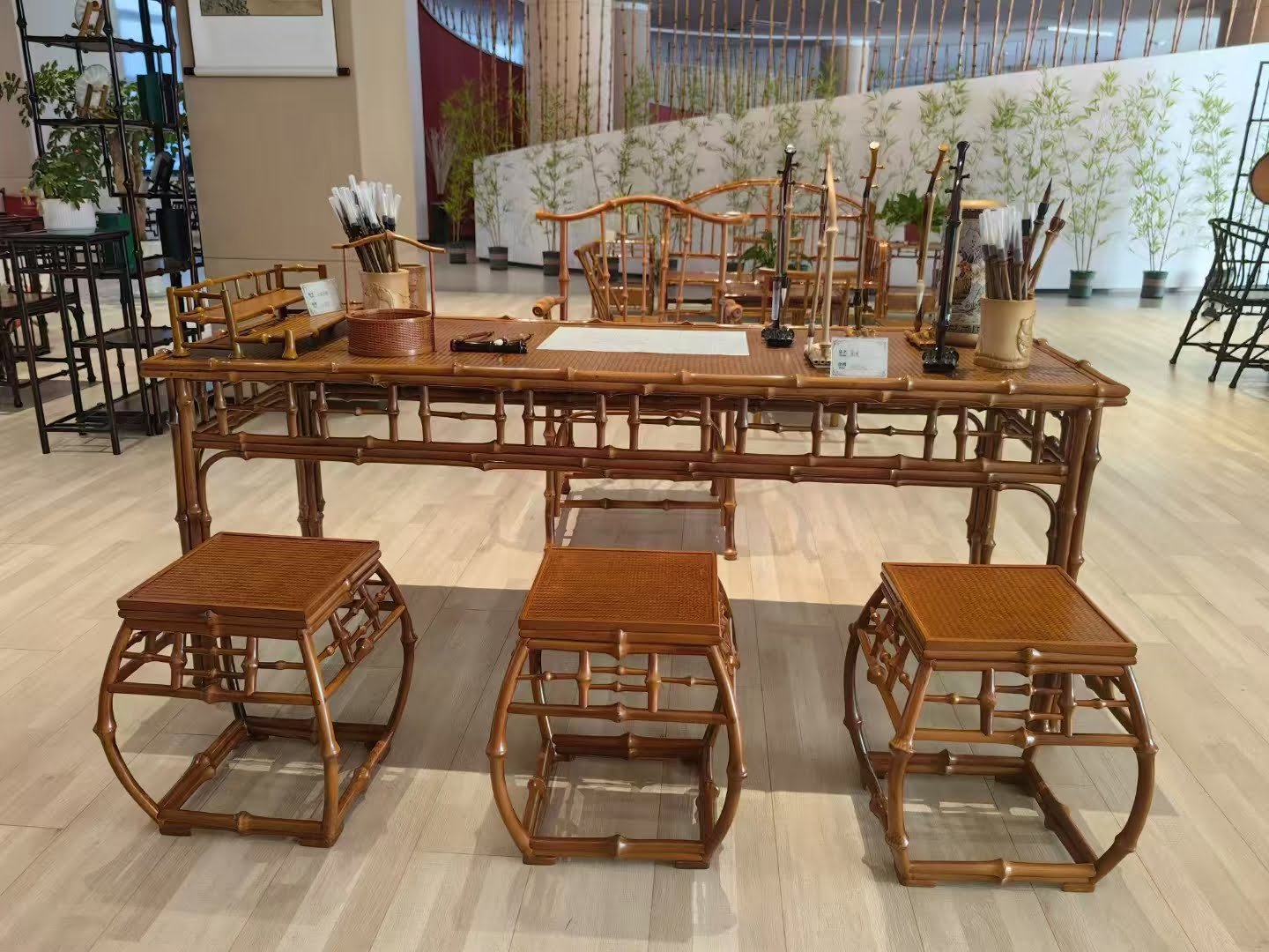 Elegant bamboo tea table set with matching stools, showcasing traditional craftsmanship in a modern interior space.